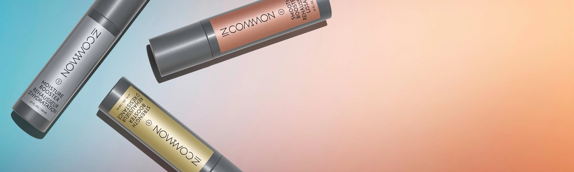 Three Booster bottles lying on a teal and peach backdrop